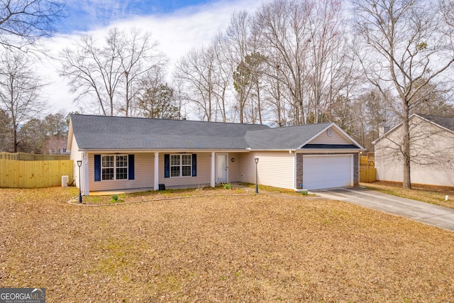 ranch-style home featuring roof with shingles, fence, driveway, and an attached garage