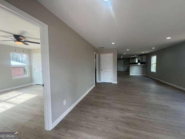 unfurnished bedroom with ceiling fan, dark wood-style flooring, visible vents, and baseboards