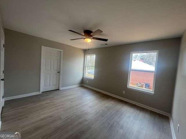 unfurnished bedroom with wood finished floors, a ceiling fan, and baseboards