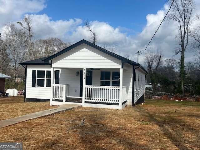 bungalow-style home with covered porch and a front lawn