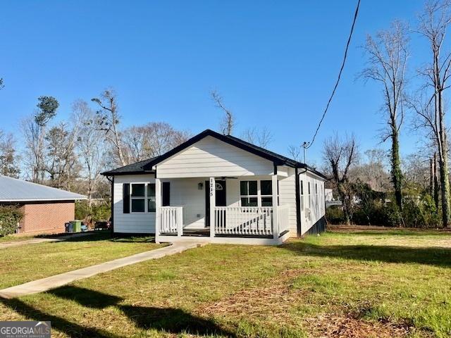 bungalow-style home featuring a porch and a front yard