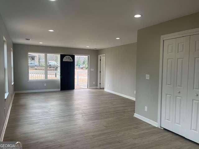 interior space with recessed lighting, wood finished floors, and baseboards