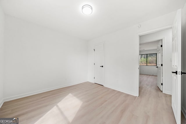 empty room featuring light wood finished floors and baseboards