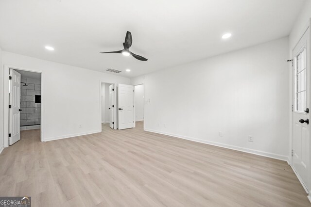 unfurnished bedroom with a spacious closet, light wood finished floors, recessed lighting, and baseboards