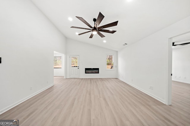 unfurnished living room featuring a ceiling fan, a glass covered fireplace, and light wood finished floors