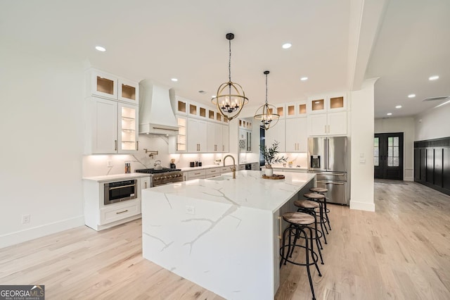 1523 Grayson Pkwy, Grayson, GA 30017 - kitchen featuring stainless steel fridge, premium range hood, a chandelier, light wood finished floors, and a large island