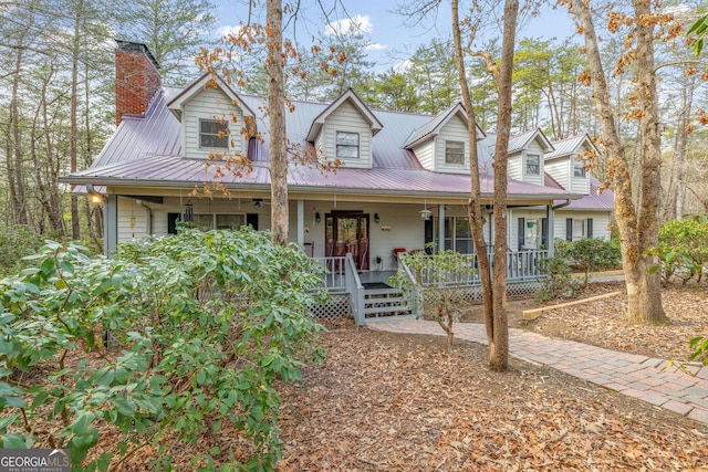 cape cod-style house with covered porch and metal roof