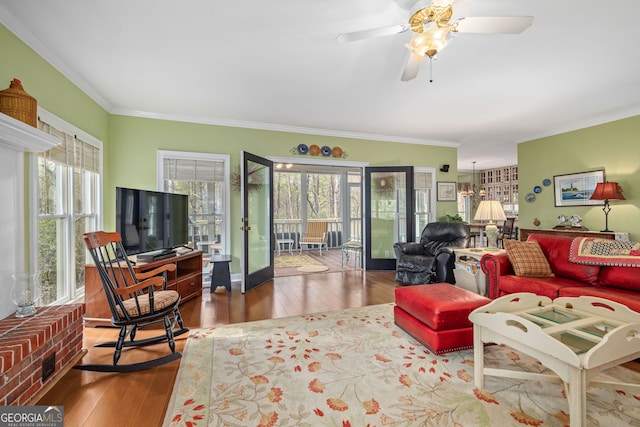 living area with wood finished floors, a ceiling fan, and crown molding