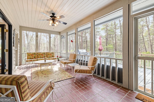 sunroom / solarium featuring wooden ceiling, a ceiling fan, and a wealth of natural light