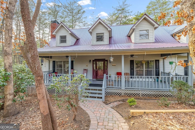 view of front of home with ceiling fan, metal roof, a porch, and a chimney