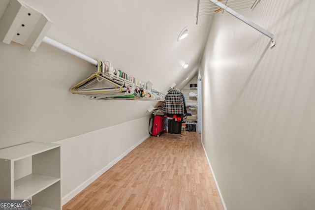 walk in closet with vaulted ceiling and wood finished floors