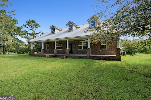 new england style home with a front yard, covered porch, and brick siding