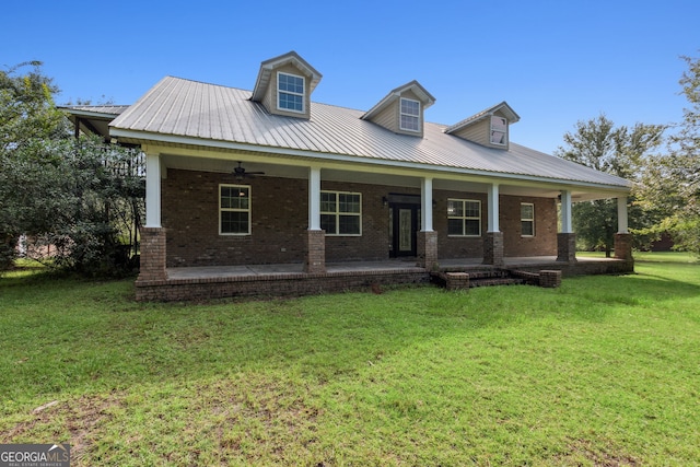 view of front of property featuring brick siding, a porch, a front yard, metal roof, and ceiling fan