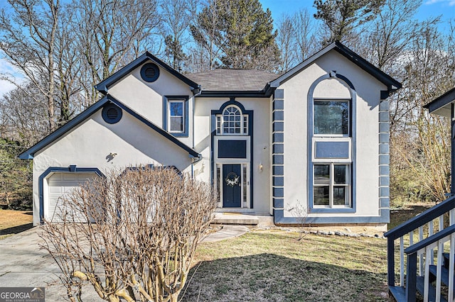 view of front of home with driveway, an attached garage, and stucco siding