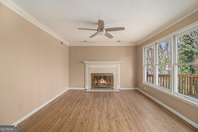 unfurnished living room featuring crown molding, light wood-style flooring, and a healthy amount of sunlight