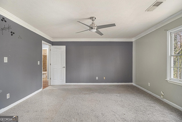 carpeted spare room with a textured ceiling, visible vents, and a wealth of natural light