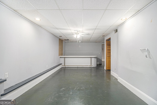 interior space with visible vents, baseboards, a ceiling fan, finished concrete floors, and a paneled ceiling