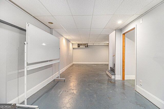 finished basement featuring stairs, baseboards, and a drop ceiling