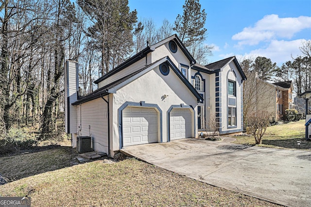 exterior space with a chimney, stucco siding, concrete driveway, a garage, and cooling unit