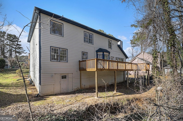 rear view of house featuring a wooden deck