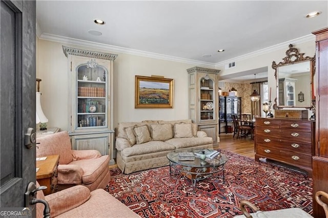 living room with crown molding, recessed lighting, visible vents, and wood finished floors