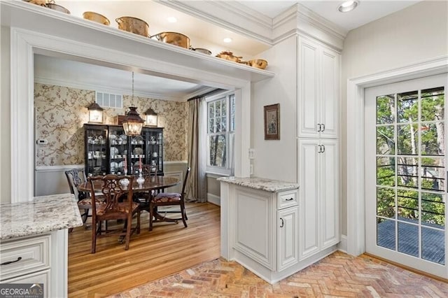 interior space featuring brick floor, wainscoting, and wallpapered walls