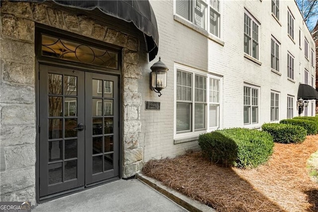 doorway to property featuring french doors and brick siding