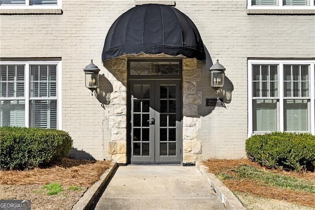 view of exterior entry with french doors and brick siding