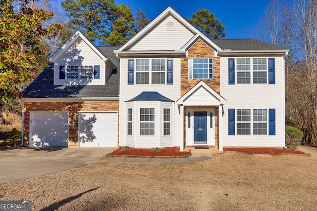 view of front of house featuring concrete driveway and a shingled roof