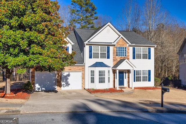 view of front facade with driveway and a shingled roof