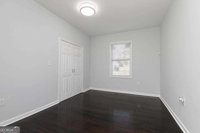 unfurnished room featuring dark wood finished floors and baseboards