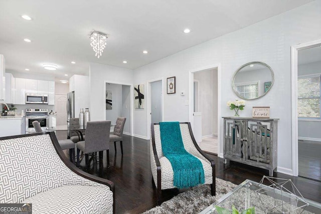 dining space featuring recessed lighting, a notable chandelier, dark wood finished floors, and baseboards