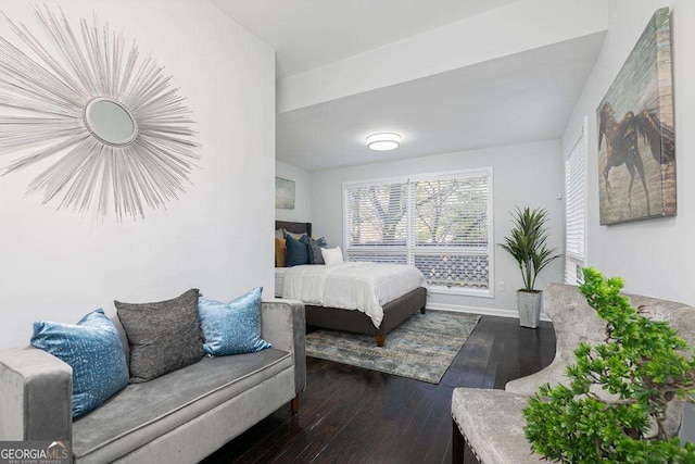 bedroom with dark wood finished floors and baseboards