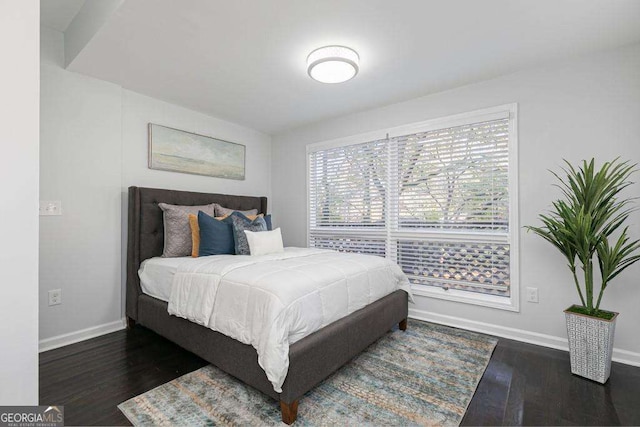 bedroom featuring dark wood finished floors and baseboards