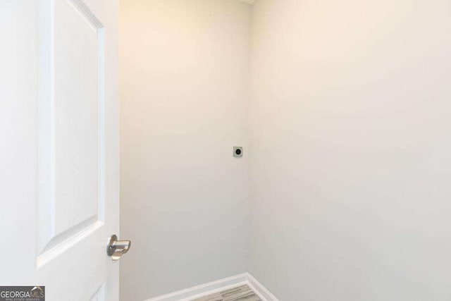 laundry room featuring baseboards, laundry area, wood finished floors, and hookup for an electric dryer