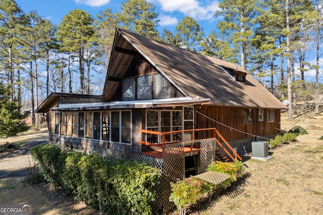 view of side of home with a sunroom, stairway, and central air condition unit