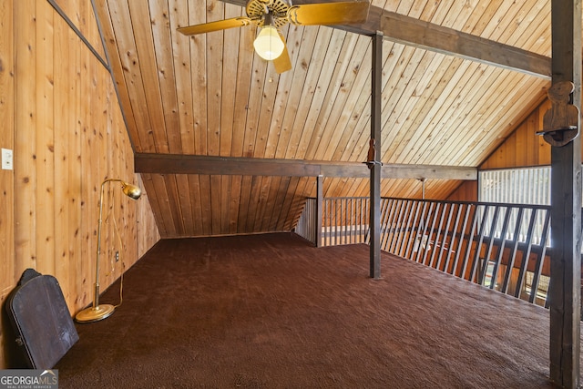 interior space featuring vaulted ceiling with beams, wooden walls, wood ceiling, a ceiling fan, and carpet