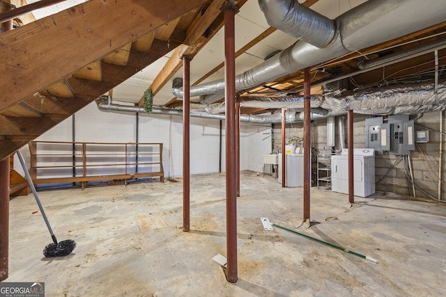 unfinished basement with electric panel and washing machine and clothes dryer