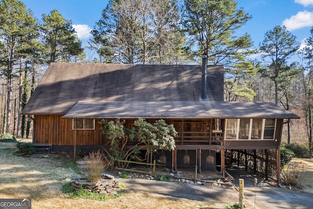 view of front of house with a carport, driveway, and a sunroom