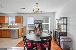 dining area with a notable chandelier, visible vents, and a textured ceiling