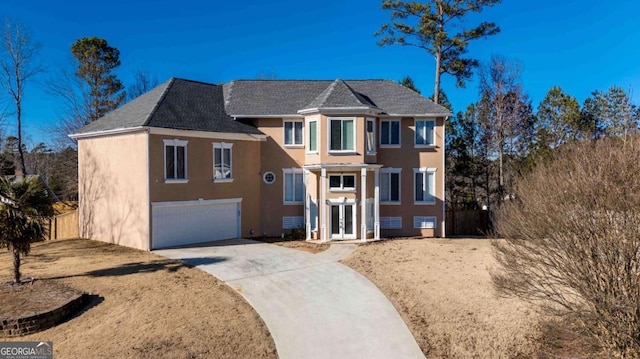 view of front of house with a garage, concrete driveway, and stucco siding