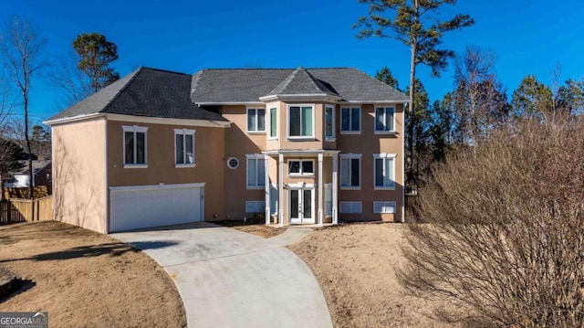 view of front of property with concrete driveway, an attached garage, and stucco siding