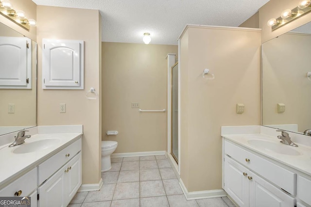 bathroom with a textured ceiling, a stall shower, a sink, and tile patterned floors