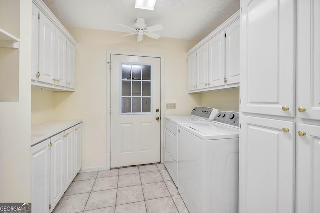 laundry area with ceiling fan, a textured ceiling, light tile patterned flooring, independent washer and dryer, and cabinet space