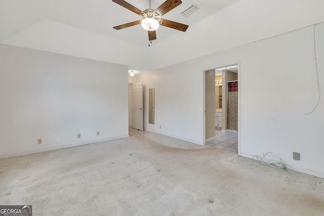 spare room featuring light carpet, baseboards, visible vents, a raised ceiling, and a ceiling fan