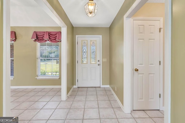 entrance foyer with light tile patterned floors and baseboards