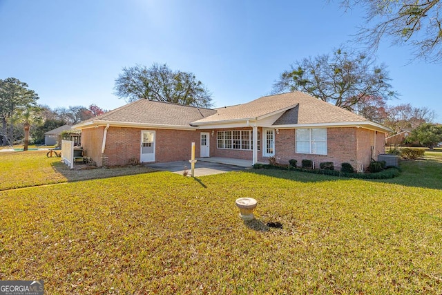 single story home featuring a front yard, brick siding, and a patio