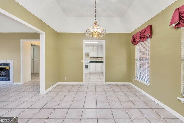 unfurnished dining area with light tile patterned flooring, baseboards, and a tile fireplace