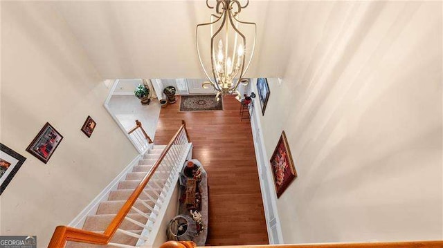 1657 Stilesboro Ridge Dr, Kennesaw, GA 30152 - stairway featuring a chandelier, a towering ceiling, and wood finished floors