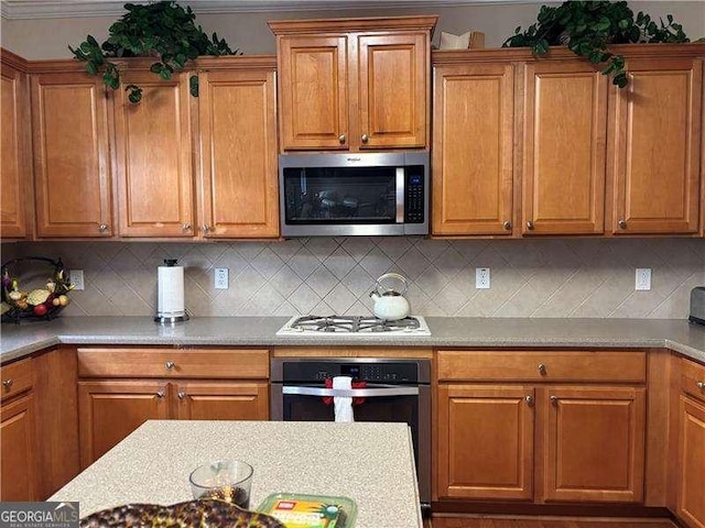 1657 Stilesboro Ridge Dr, Kennesaw, GA 30152 - kitchen featuring stainless steel appliances, brown cabinetry, backsplash, and light countertops
